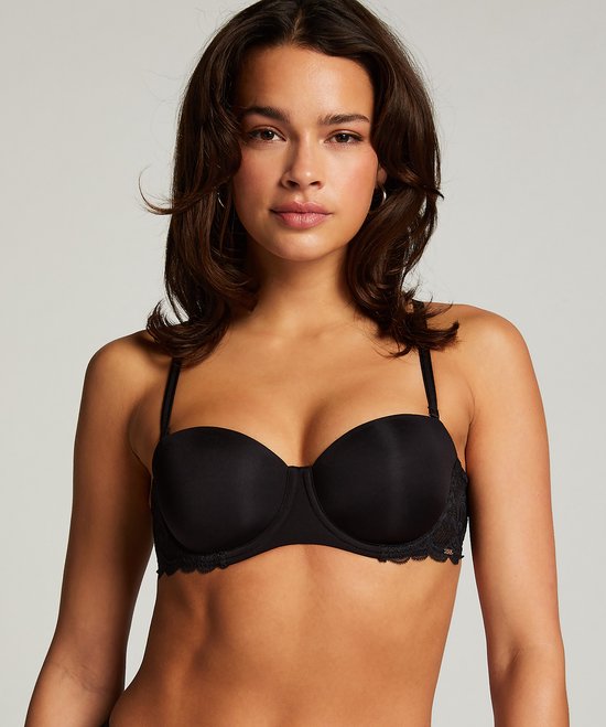 Model met donkerbruin haar in een zwarte balconnetbeha met kanten afwerking aan de zijkanten.