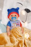 BABY born pop in bed met blauwe muts, romper en tutje. Met gouden deken.