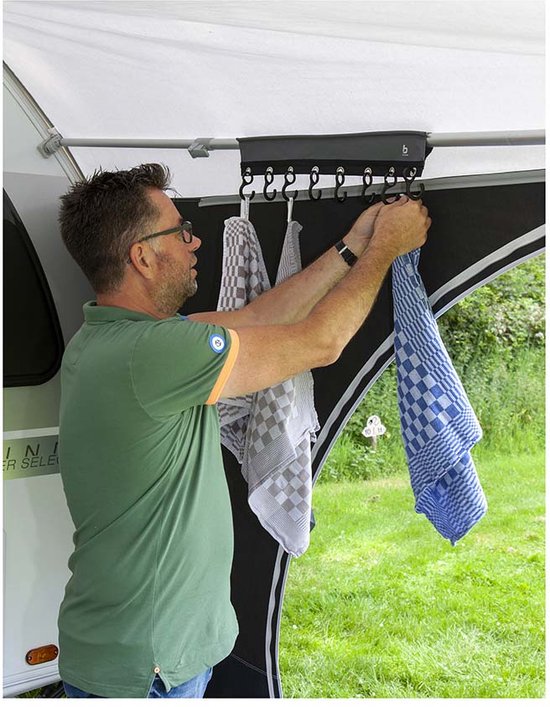 Man hangt een blauw-wit geblokte theedoek op aan een grijze organizer met 8 haken.