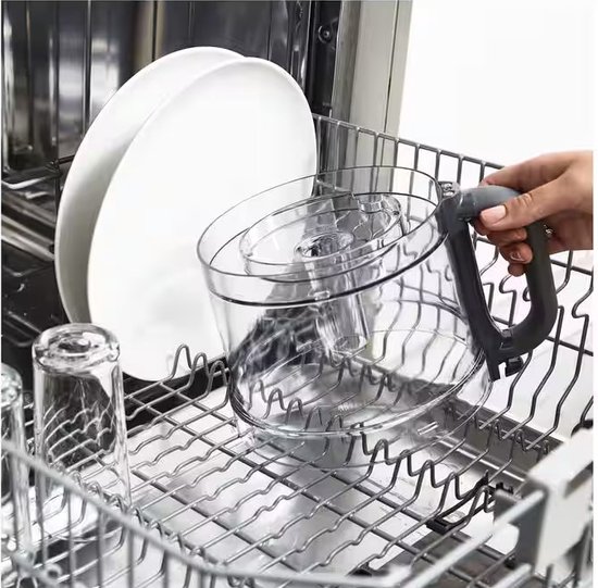 Une main place le bol en plastique d'un robot culinaire Kenwood dans un lave-vaisselle entre des assiettes et des verres.