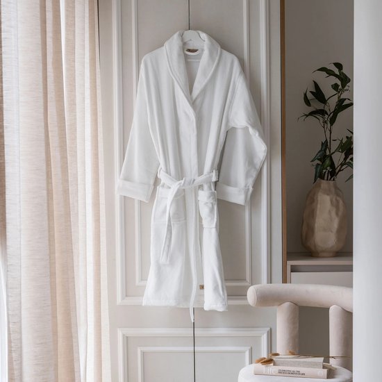 Peignoir blanc Walra, suspendu à une porte.