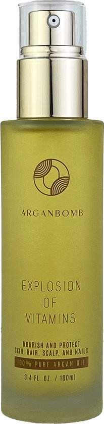 Glazen fles met goudkleurige pomp, gevuld met olijfgroene olie. Goudkleurige tekst: 'ARGANBOMB EXPLOSION OF VITAMINS'.