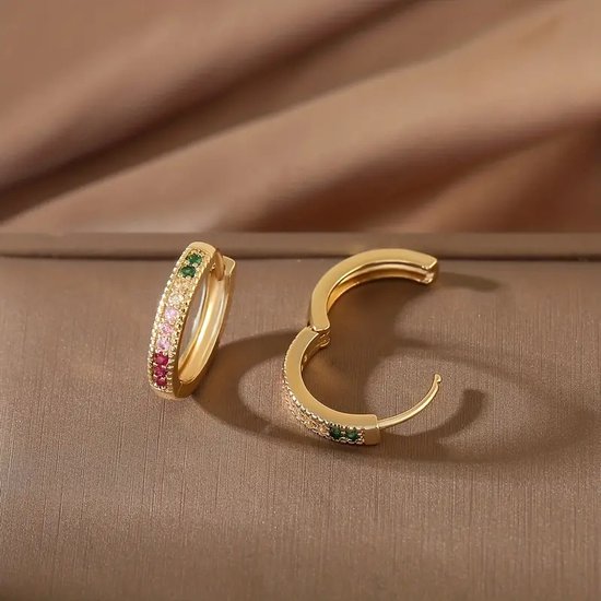 Gouden oorringen, één open, bezet met groene, roze en rode zirkonen, glanzend.
