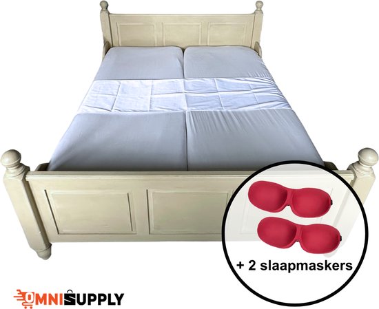 Ledikant met een beige, houten frame, opgemaakt met een grijs hoeslaken en witte sprei. Inclusief twee rode slaapmaskers.