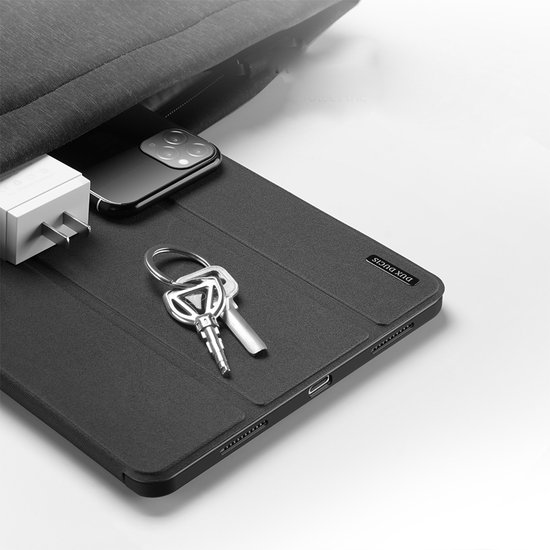 Zwarte iPad Pro hoes met sleutels en een iPhone die in een tas worden gestopt.