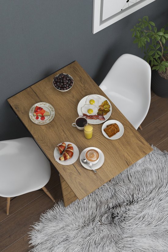 Houten opklapbare tafel, geopend voor ontbijt met croissants, eieren en koffie, met witte stoelen.