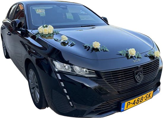 Zwarte Peugeot 308 met decoratie van gele rozen en groene bladeren op de motorkap.