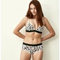 Meisje met luipaardprint beugel bh en shorts met zwarte bandjes.