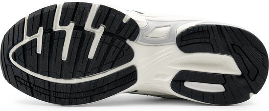Zool van witte en zwarte sneaker met profiel en schokabsorptie.