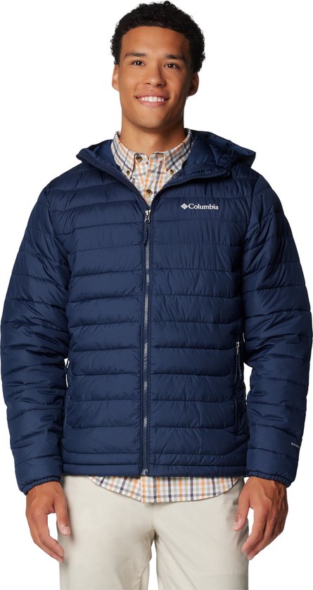Homme aux cheveux foncés portant une veste à capuche matelassée bleu marine et une chemise à carreaux.