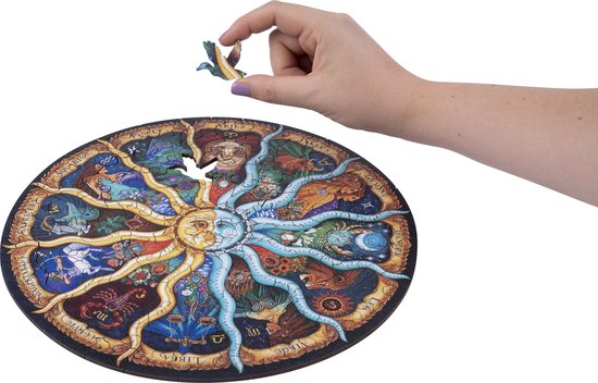 Hand voegt een dierenpuzzelstukje toe aan de puzzel van de dierenriem. Zonnige en maankant in het midden.