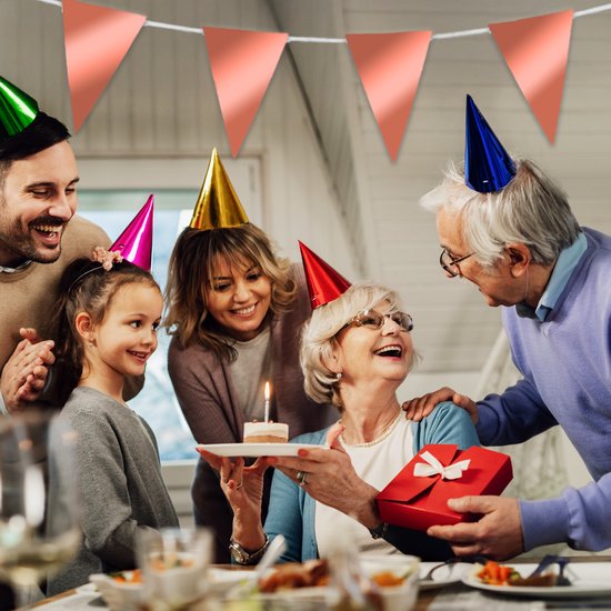 Une famille célèbre un anniversaire, avec des guirlandes et un gâteau avec une seule bougie.