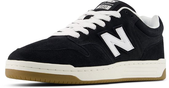 Zwarte suède New Balance sneakers met witte N-logo's, witte veters en bruine zool.