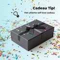 Zwarte geschenkdoos met zwarte strik, omringd door gekleurd confetti.