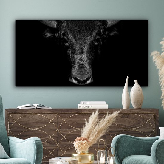 Grande toile noir et blanc d'une tête de taureau sur un fond noir uni.