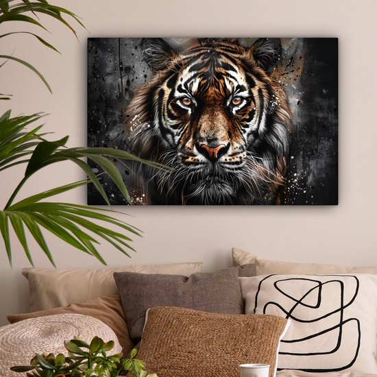 Een tijgerportret hangt boven een bed met kussens en een plant.