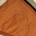 Oranje waterafstotende stof met druppels, close-up.