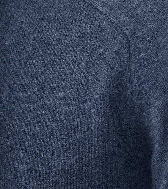 Detail van de blauwe lamswollen stof op de schouder van een trui.