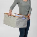Vrouw met grijze Brabantia wasmand gevuld met wasgoed.