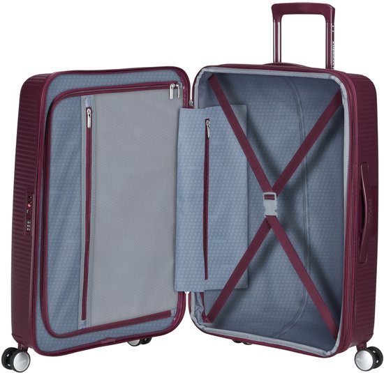 Open bordeauxrode American Tourister spinner koffer met binnenvakken, pakriemen en ritssluiting.