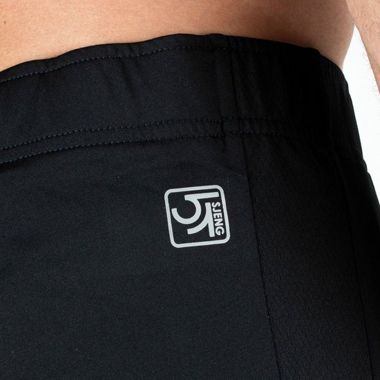 Detailopname zwarte trainingsbroek met logo 'SJENG' op de heup.