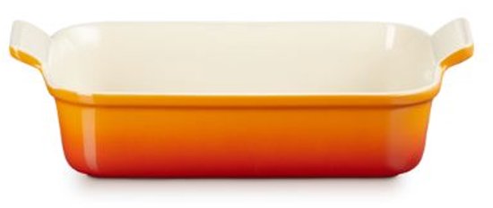 Oranjerode ovenschaal met witte handvatten en een crèmekleurige binnenkant.