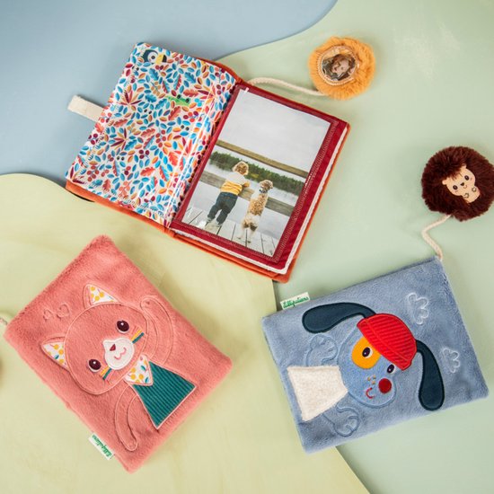 Drie stoffen boekjes: een roze met kat, een oranje met leeuw, en een lichtblauw met hond. Met egel speeltje.