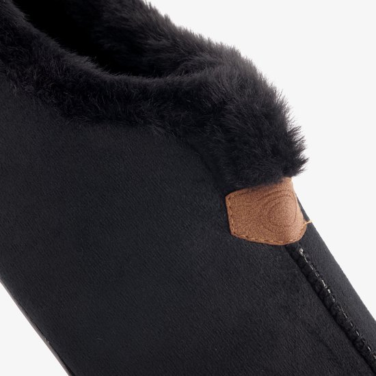 Detail van de zwarte pantoffel met imitatiebont voering en bruin label.