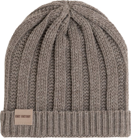 Gebreide taupekleurige Knit Factory muts met ribbelpatroon en lederen merklabel.
