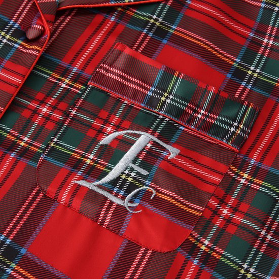 Detail van de borstzak van de pyjamajas met 'E' geborduurd, rood ruitjespatroon.