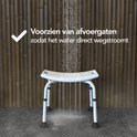 Witte douchekruk in een douche met bamboewand, met tekst 'Voorzien van afvoer gaten'.