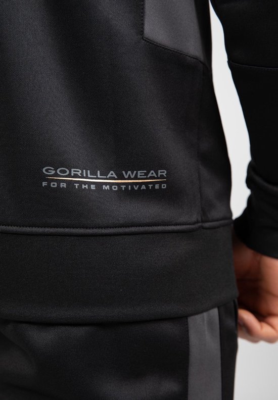 Onderkant van een zwarte trainingsjas met logo "GORILLA WEAR FOR THE MOTIVATED".