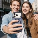 Jong stel maakt een selfie met een donkerblauw hoesje om de iPhone, straat op de achtergrond.