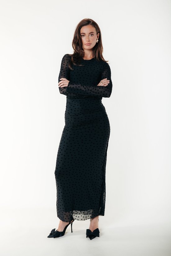 Mannequin portant une robe maxi noire moulante à manches longues avec un motif de cœurs.