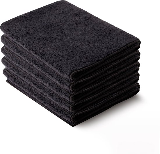 Pile de six serviettes microfibre noires, pliées avec une texture douce.