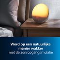 Philips wek-up light op een houten nachtkastje, die een zonsopgang nabootst en 07:00 weergeeft.