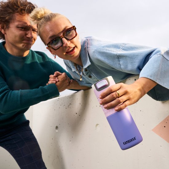 Lichtpaarse Kambukka thermosbeker met gestructureerd grijs en paars detail, vastgehouden door een vrouw.