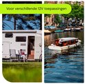 RV met stoel op gazon naast camper, en boot op gracht in stad.