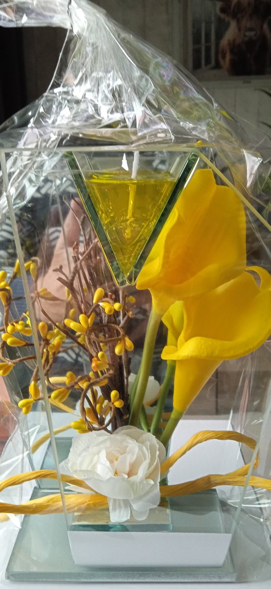 Glasdecoratie in glas met gele bloemen en gelei lichtje.