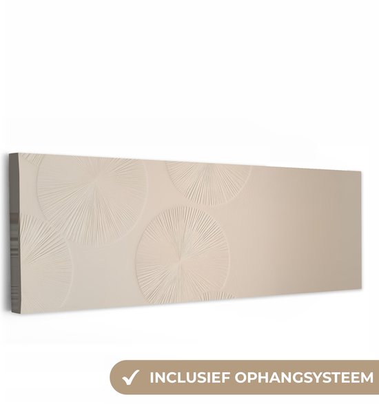 Licht beige canvas met reliëf van cirkels, met de tekst 'Inclusief ophangsysteem'.