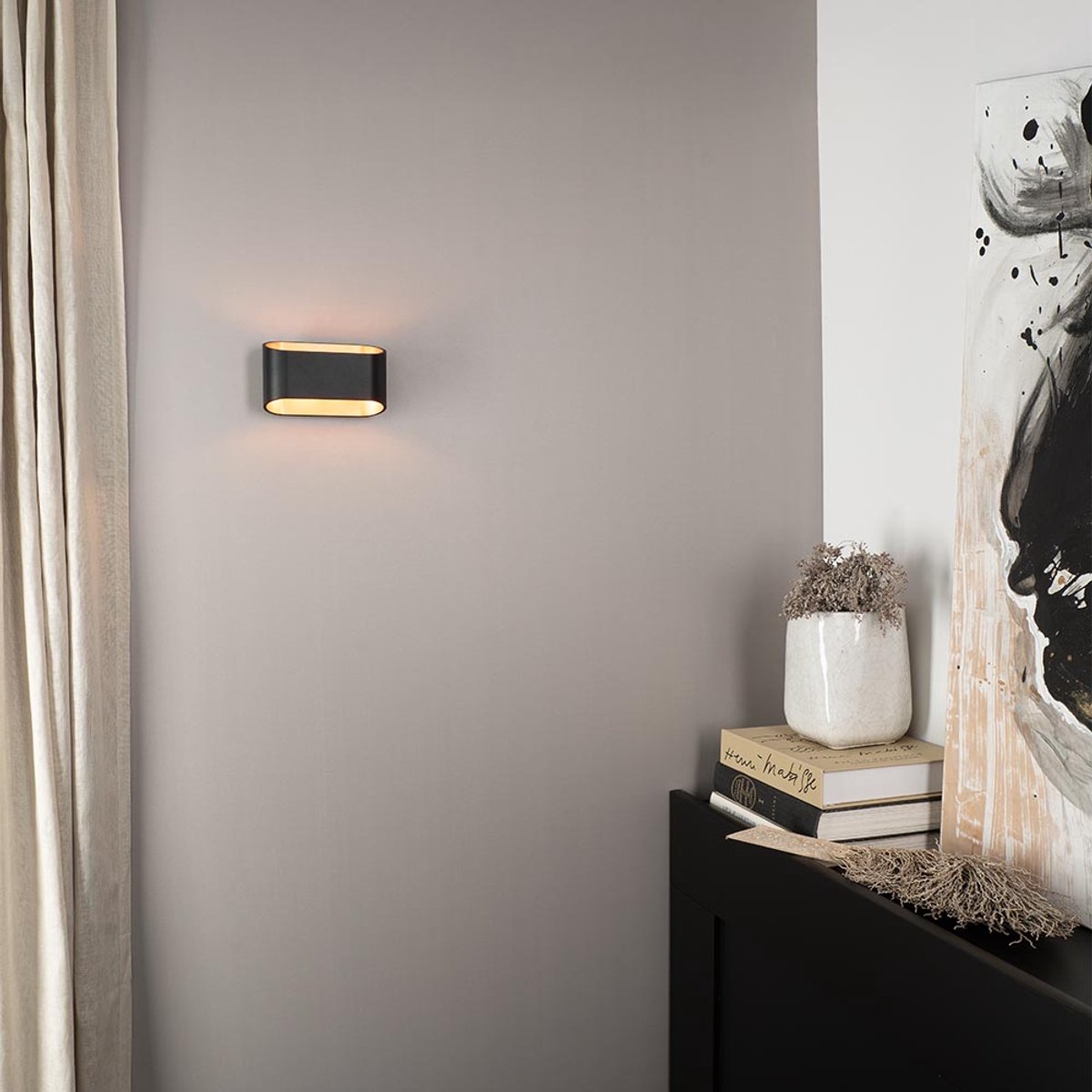Volans nero oro by LUSENZ - Ovaalvormige wandlamp met up and downlight, matzwarte coating en goudkleurig interieur