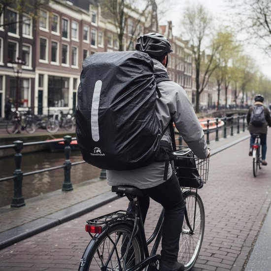 Fietser in Amsterdam met grote zwarte, waterdichte rugzak met reflecterende streep.