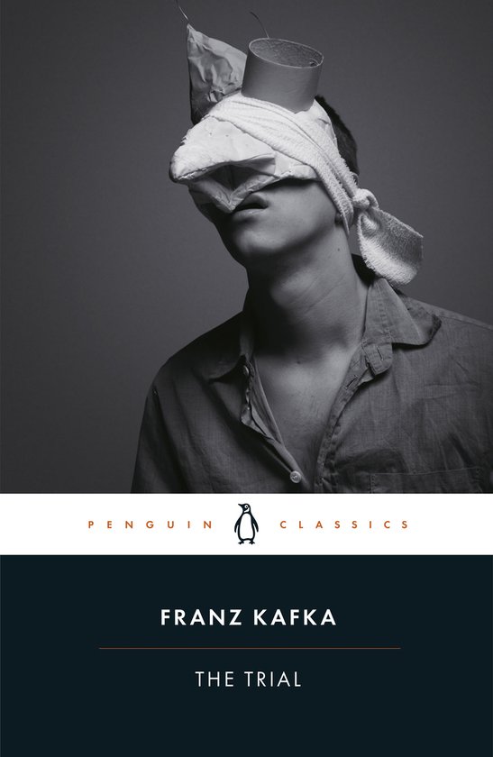 Livre avec une photo noir et blanc d'un homme le regard bandé. Titre: 'THE TRIAL' par FRANZ KAFKA.