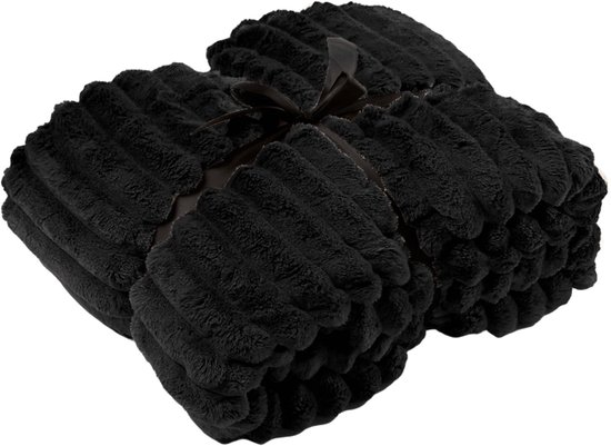 Een opgerolde, zwarte, zachte plaid met ribbelpatroon, samengebonden met een lint.