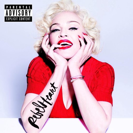 Madonna met blond krullend haar, rode lippen, rode top en "Rebel Heart" tatoeage op haar linkerarm. Ouders Advies Expliciet.