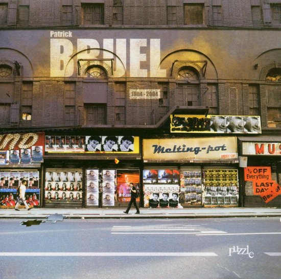 Patrick Bruel naam op een gebouw, met etalages vol posters. Een man loopt op straat.