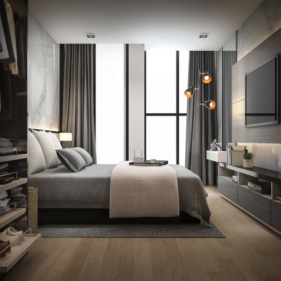 Moderne slaapkamer met een zwarte staande lamp met drie spots naast het bed.