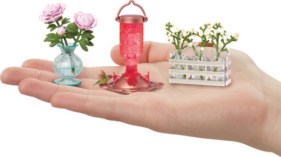 Miniatuur bloemen, kolibrie voeder en vaasjes met bloemen in hand.
