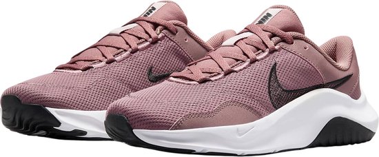 Paar roze Nike sportschoenen met witte zolen en zwarte details.