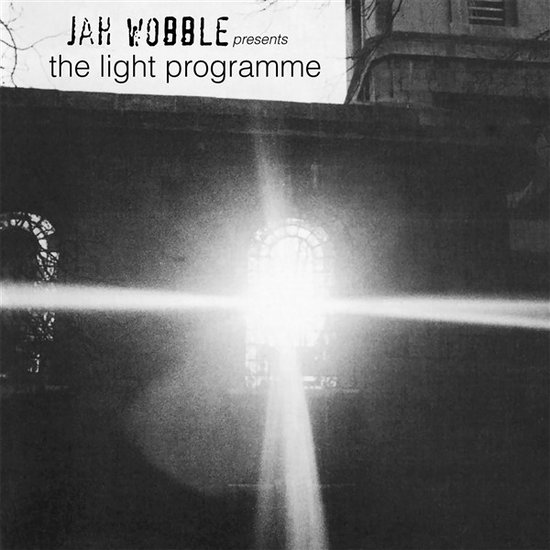 Albumcover van 'Jah Wobble presents the light programme' met een heldere lichtstraal die door een raam schijnt.